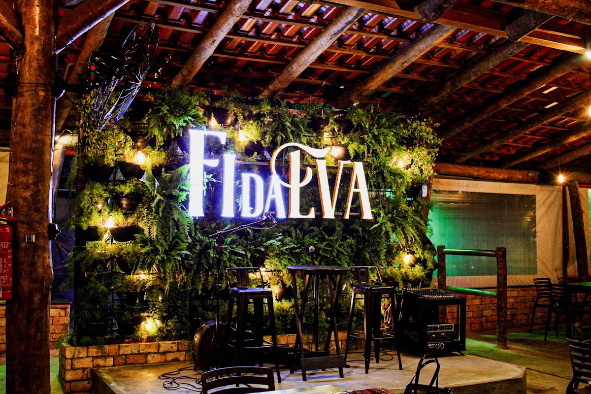 Ambiente da Fi da Eva Bar, com mesas ocupadas e iluminação quente em Uberlândia